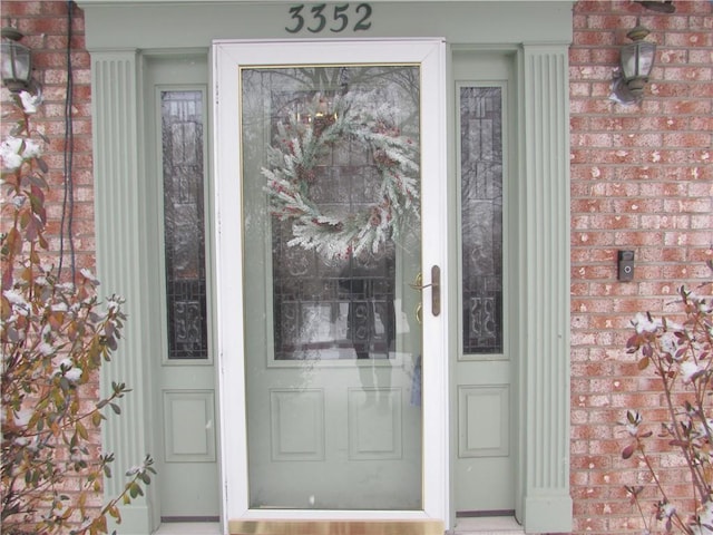 view of exterior entry with brick siding