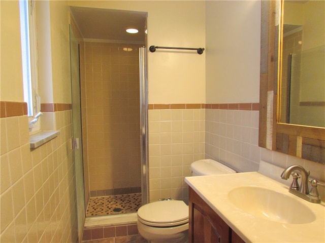 bathroom featuring vanity, toilet, tile walls, and a shower stall