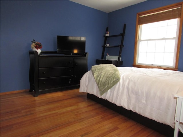 bedroom featuring baseboards and wood finished floors