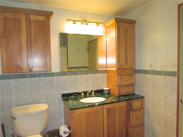 bathroom featuring toilet, tile walls, and vanity