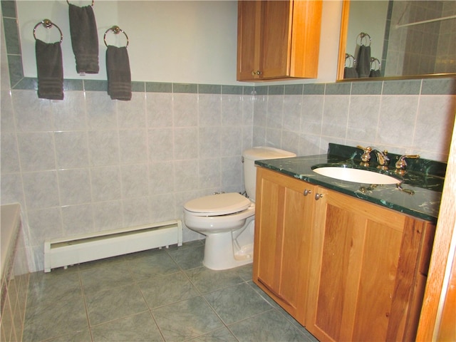 bathroom with toilet, vanity, tile patterned floors, tile walls, and a baseboard radiator