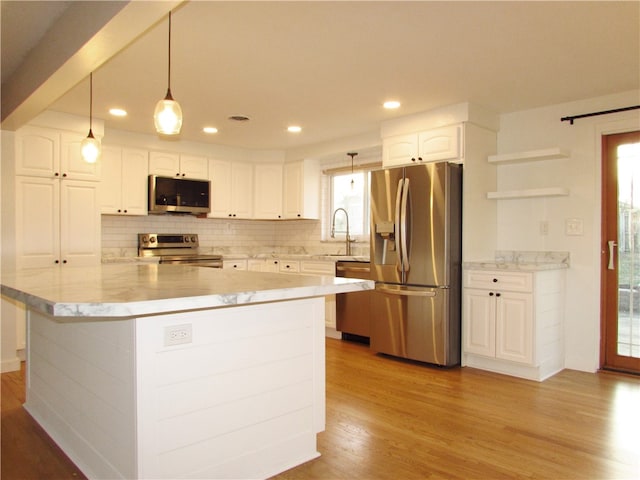 kitchen featuring open shelves, white cabinets, light wood-style floors, appliances with stainless steel finishes, and tasteful backsplash