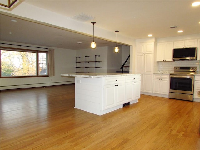 kitchen featuring light wood finished floors, white cabinets, appliances with stainless steel finishes, a baseboard heating unit, and tasteful backsplash