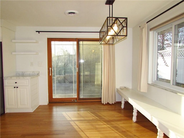 unfurnished dining area featuring light wood finished floors and a chandelier