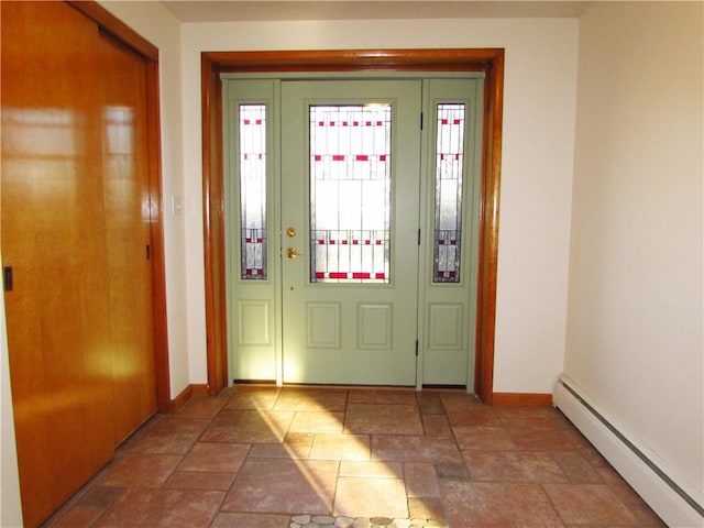 entrance foyer featuring stone finish floor, baseboards, and a baseboard radiator