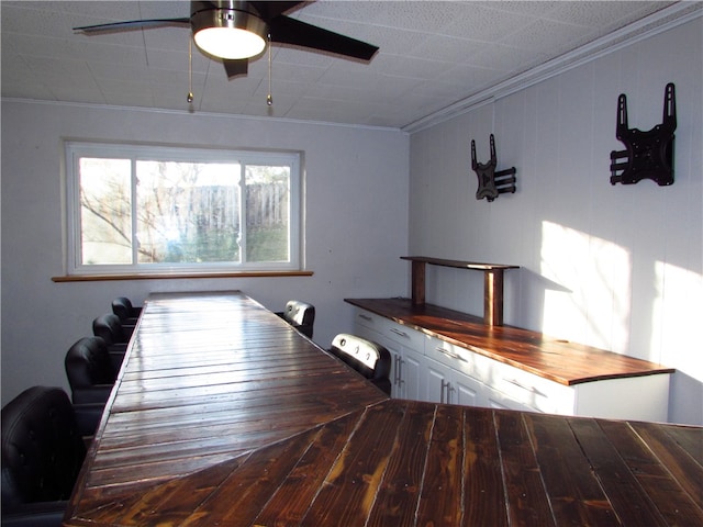 unfurnished dining area featuring a ceiling fan and ornamental molding