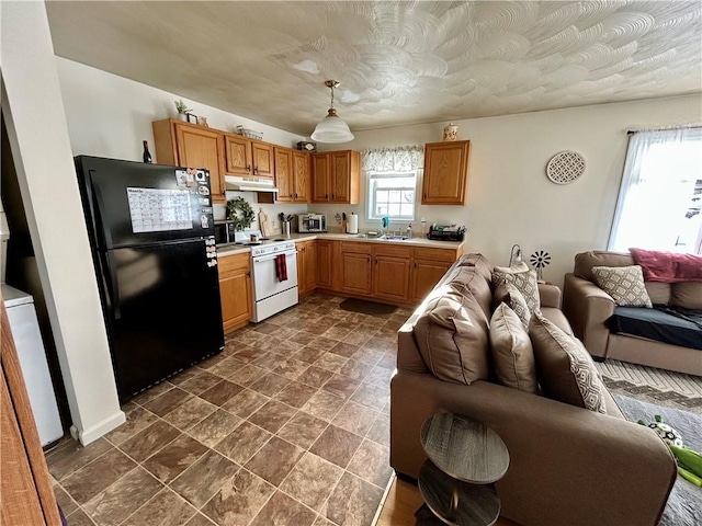 kitchen with black refrigerator, white range, decorative light fixtures, and sink