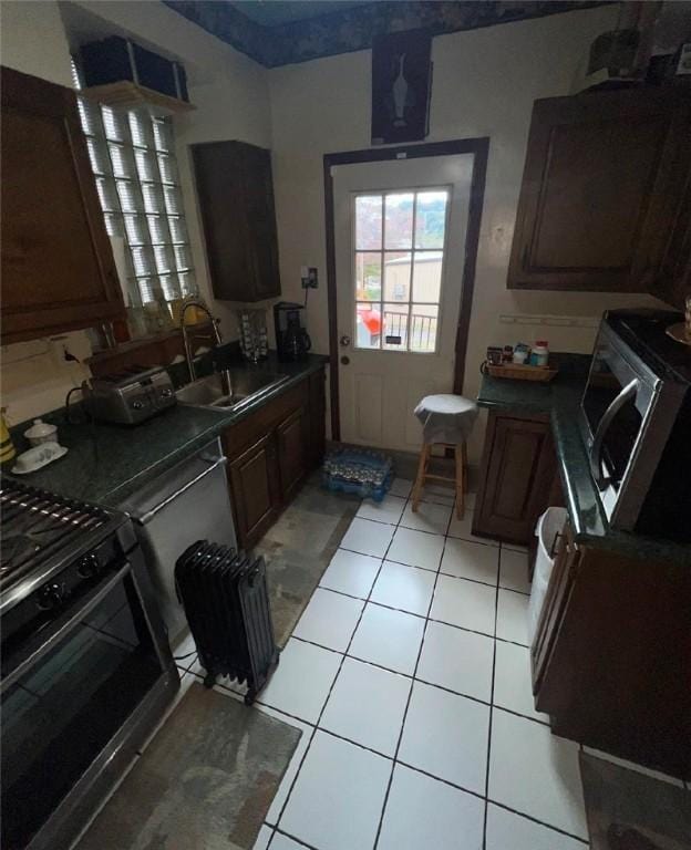 kitchen featuring light tile patterned floors, sink, and black range with gas cooktop