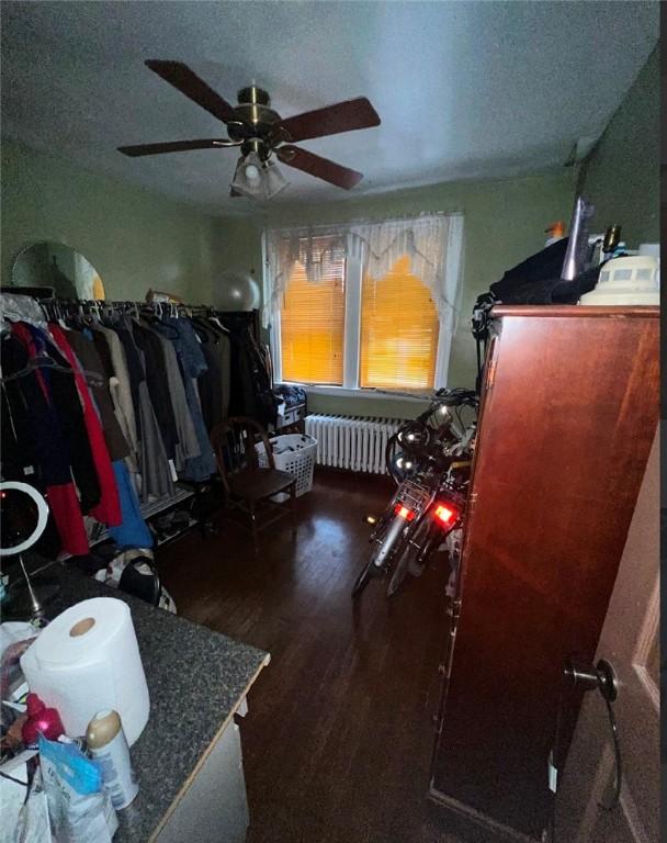 miscellaneous room with ceiling fan, radiator heating unit, dark wood-type flooring, and a textured ceiling