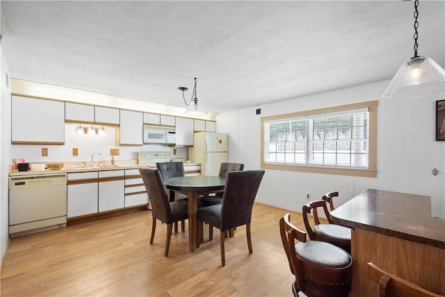 dining room featuring a textured ceiling, light hardwood / wood-style floors, and sink