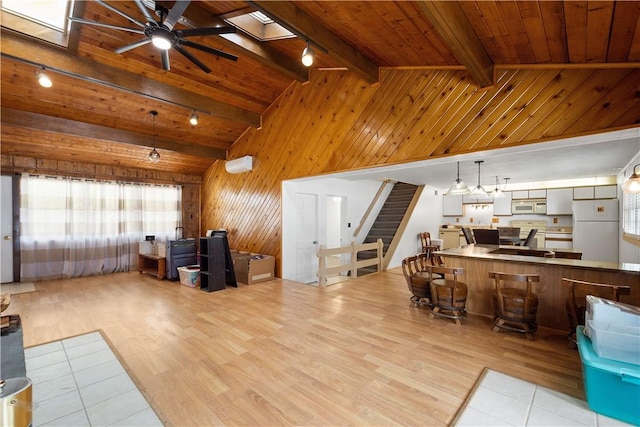 living room with beamed ceiling, wood walls, wooden ceiling, and rail lighting