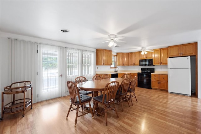 dining space featuring light wood-type flooring, ceiling fan, and sink