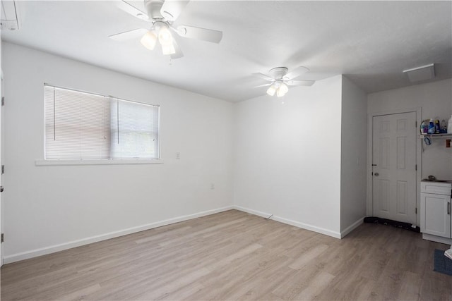 empty room with ceiling fan and light hardwood / wood-style floors