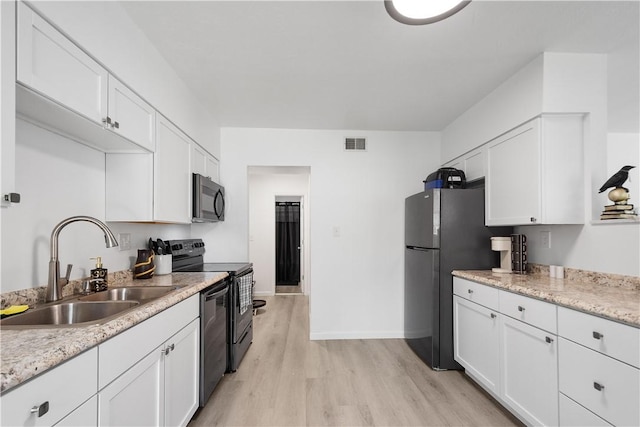 kitchen with black appliances, light wood-type flooring, white cabinetry, and sink