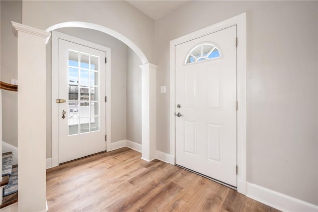 foyer with light hardwood / wood-style flooring and ornate columns