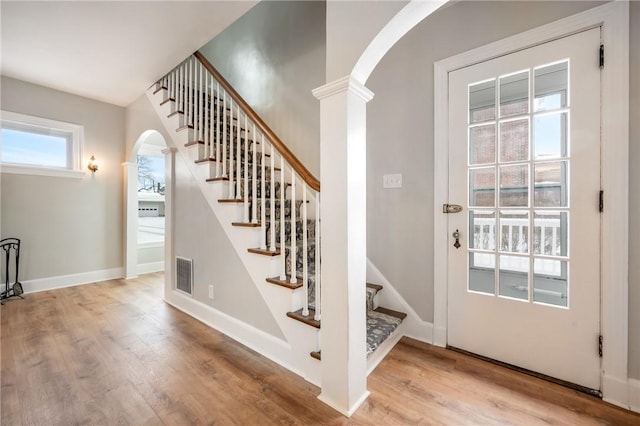 3134 Main St, West Middlesex Boro, PA 16159 - staircase with wood finished floors, visible vents, arched walkways, baseboards, and decorative columns