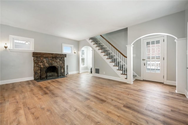 unfurnished living room featuring plenty of natural light, light hardwood / wood-style floors, and a fireplace