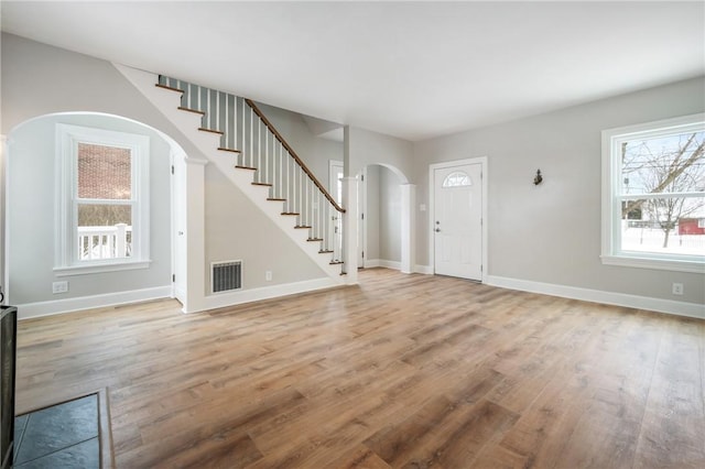 3134 Main St, West Middlesex Boro, PA 16159 - foyer entrance with stairway, visible vents, arched walkways, baseboards, and light wood-style flooring