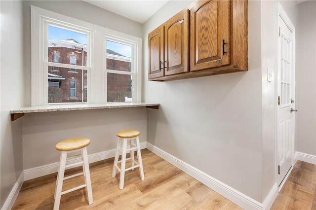 interior space with light hardwood / wood-style floors and light stone countertops