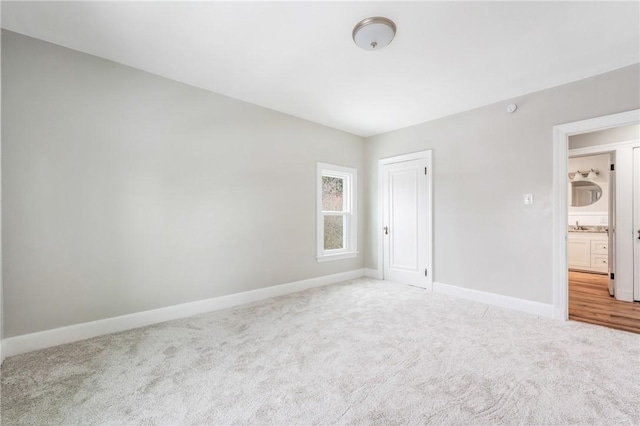 unfurnished bedroom featuring a closet, carpet floors, and sink