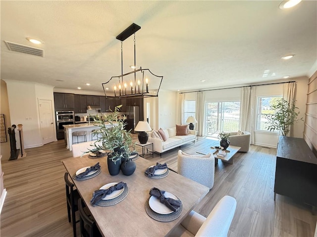 dining space featuring hardwood / wood-style floors and an inviting chandelier