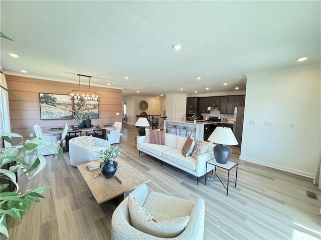 living room featuring a chandelier and light hardwood / wood-style flooring