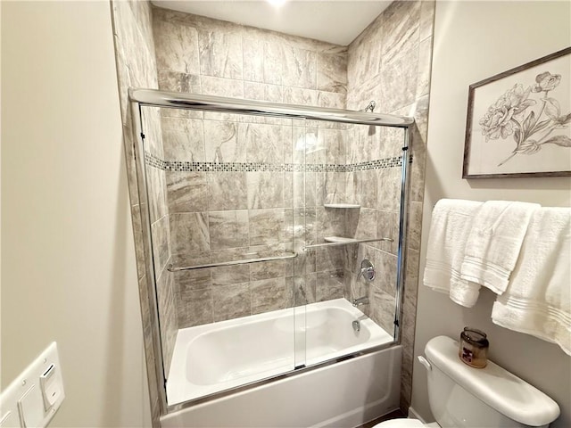 bathroom with toilet and bath / shower combo with glass door