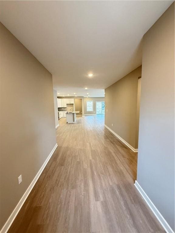 unfurnished living room featuring wood finished floors and baseboards