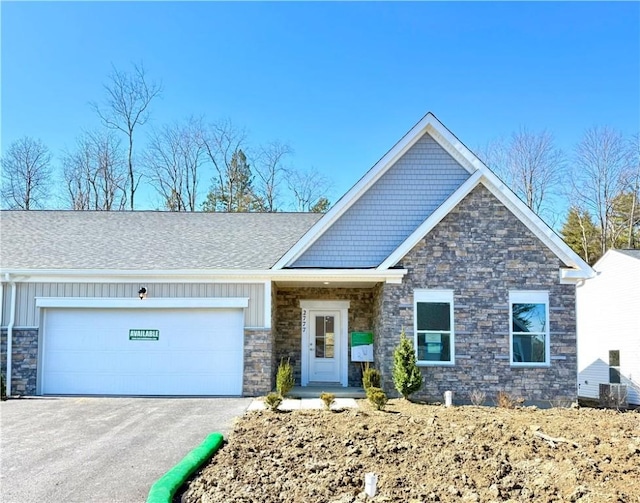 craftsman-style home with aphalt driveway, a garage, stone siding, and board and batten siding