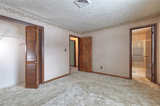 unfurnished bedroom featuring light carpet, a textured ceiling, and a closet