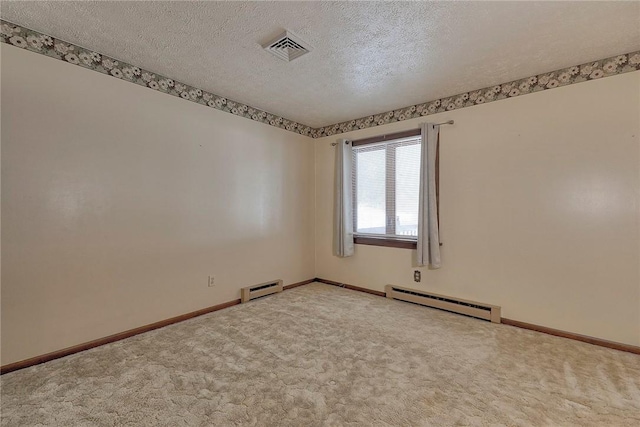 carpeted spare room with a textured ceiling and a baseboard heating unit