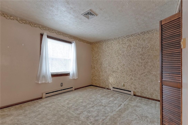 spare room featuring baseboard heating, light carpet, and a textured ceiling