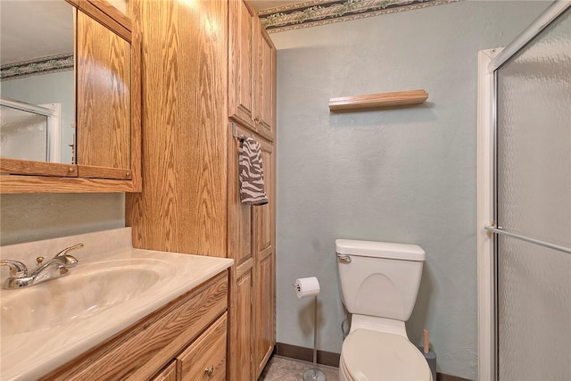 bathroom featuring vanity, an enclosed shower, and toilet