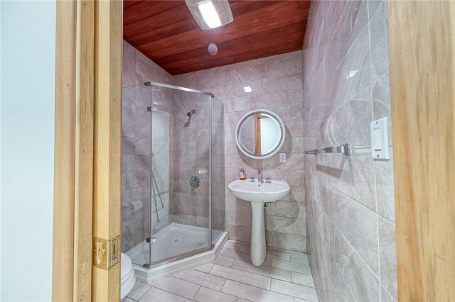 bathroom with wooden ceiling, tile patterned floors, sink, tile walls, and a shower with shower door