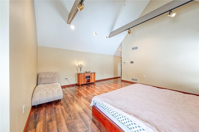 bedroom featuring lofted ceiling with beams and hardwood / wood-style flooring