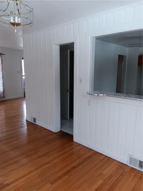 empty room featuring hardwood / wood-style floors and a chandelier