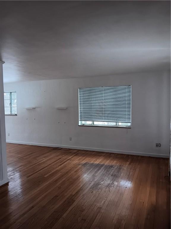 empty room with dark hardwood / wood-style flooring