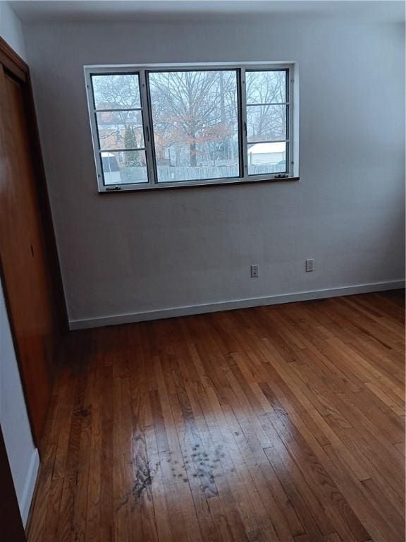 unfurnished room featuring plenty of natural light and dark hardwood / wood-style flooring