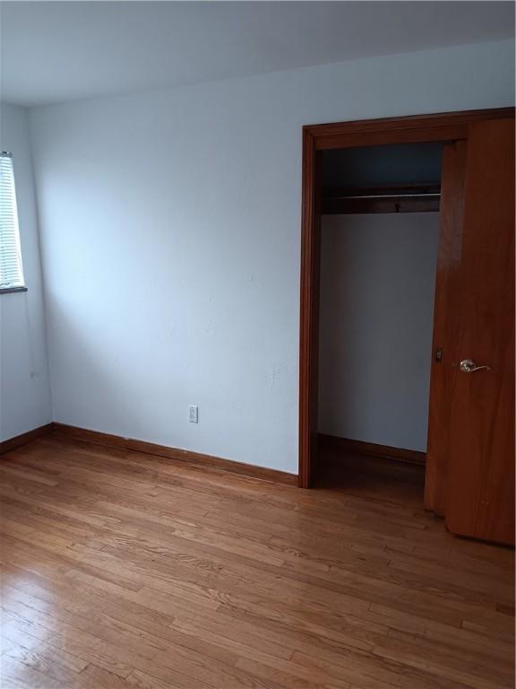 unfurnished bedroom with light hardwood / wood-style floors and a closet