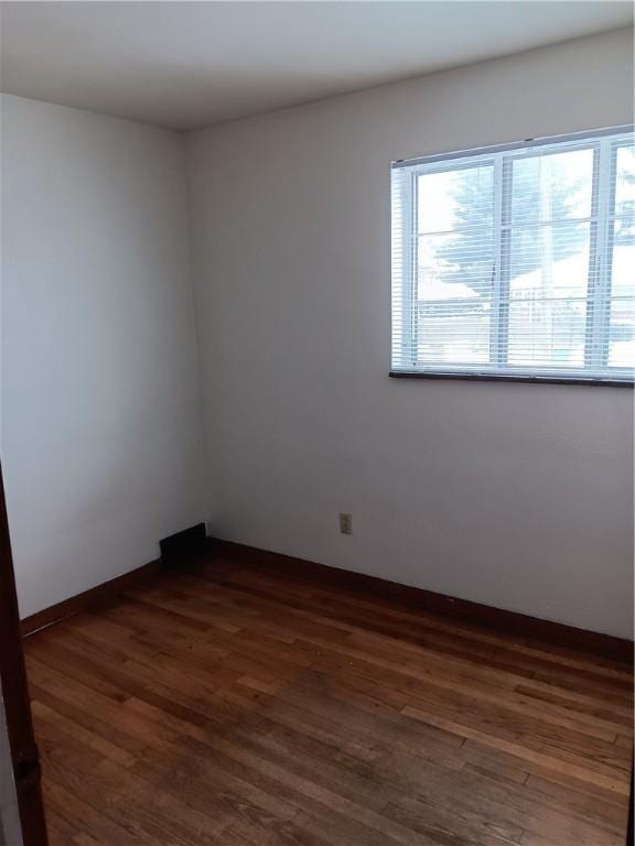 unfurnished room with dark hardwood / wood-style flooring