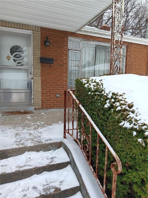 snow covered property entrance with covered porch