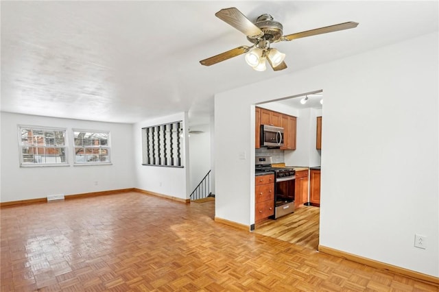 unfurnished living room with ceiling fan and light parquet flooring