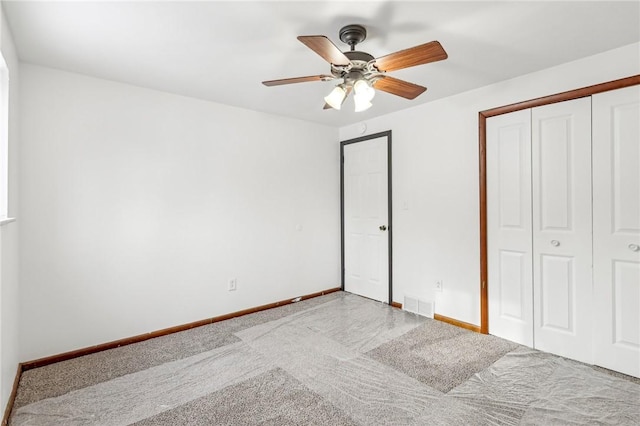 unfurnished bedroom with ceiling fan, light carpet, and a closet