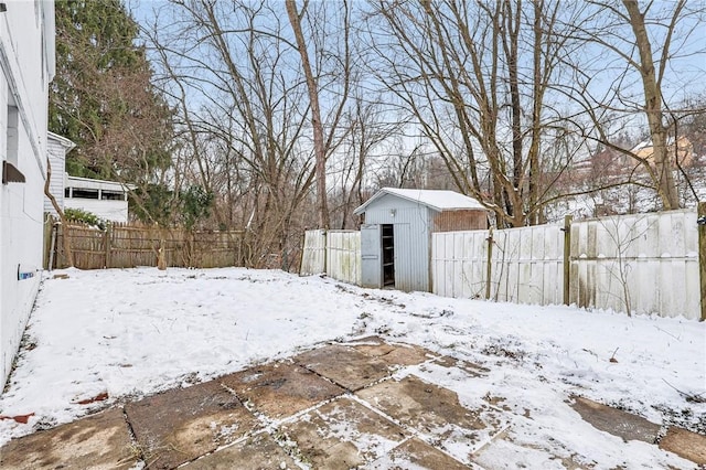 yard layered in snow with a shed