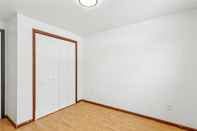 unfurnished bedroom with a closet and light hardwood / wood-style flooring