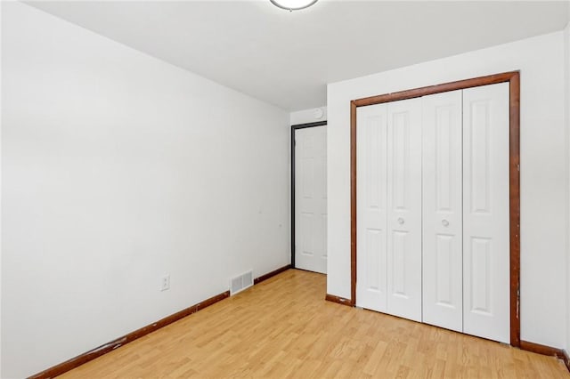 unfurnished bedroom featuring a closet and light hardwood / wood-style flooring