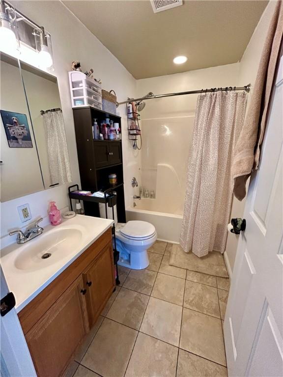 full bathroom with toilet, shower / tub combo with curtain, vanity, and tile patterned flooring