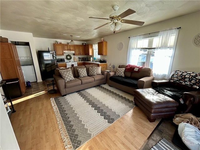 living room featuring wood-type flooring, a textured ceiling, and ceiling fan