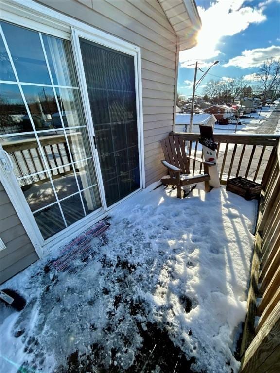 view of snow covered back of property