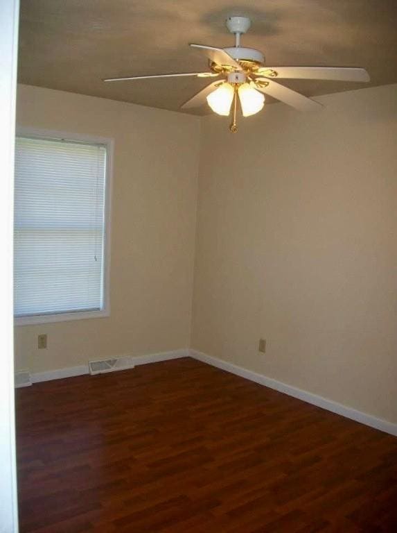 empty room with dark hardwood / wood-style flooring and ceiling fan